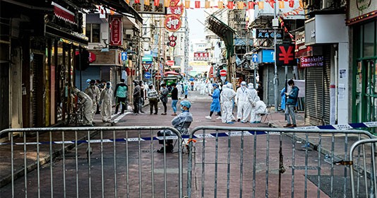 Government workers wear personal protective equipment are seen within the lockdown area in Jordon district. Hong Kong government locked down tens of thousand of residents to contain a worsening outbreak of the coronavirus. 